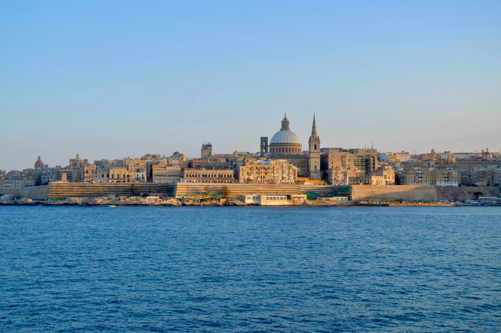 Capture of the majestic skyline of Valletta, Malta, featuring iconic architecture under a clear blue sky.
