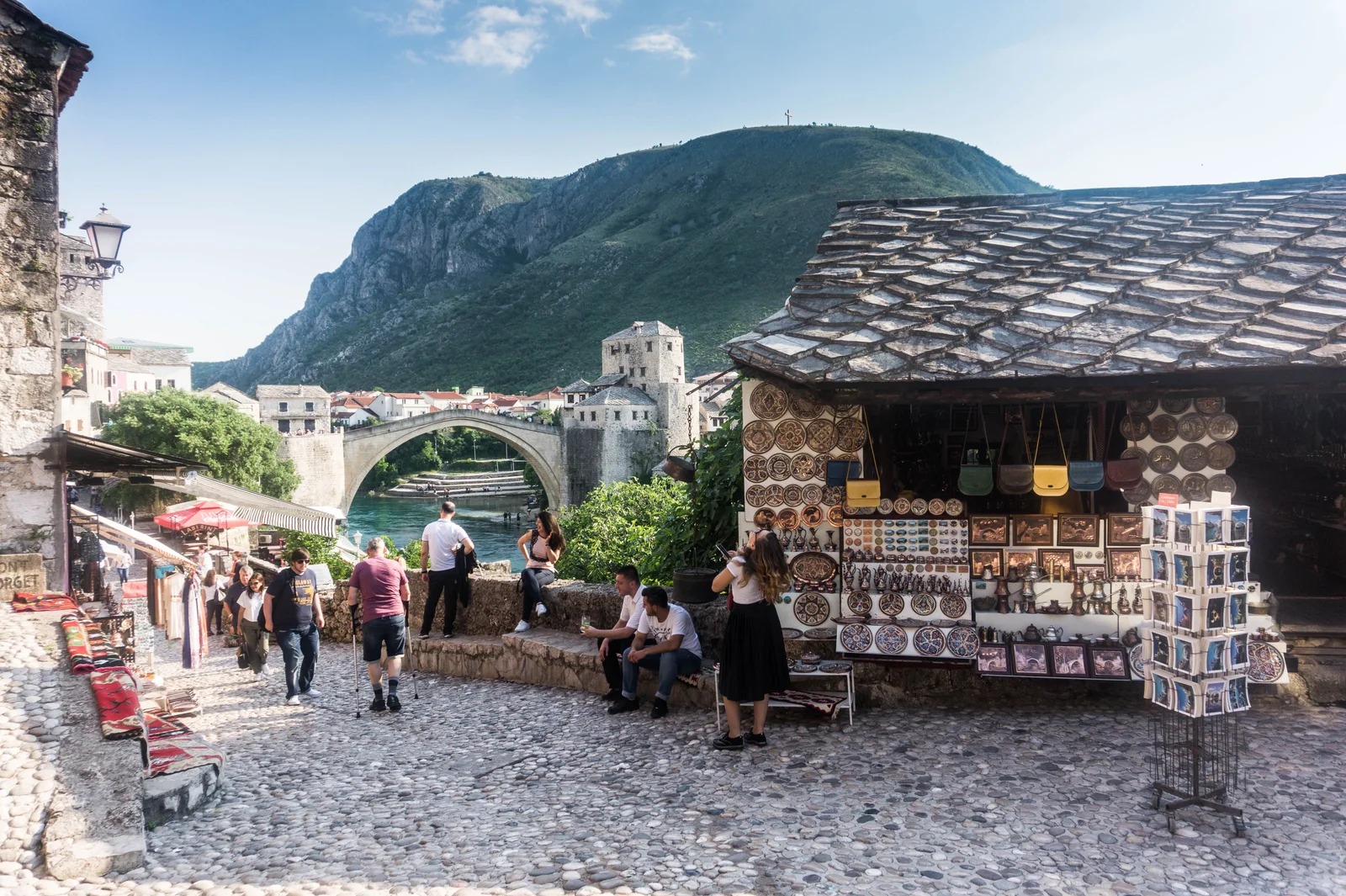 Explore the scenic and traditional streets of Mostar, showcasing the iconic Stari Most and vibrant market scene.