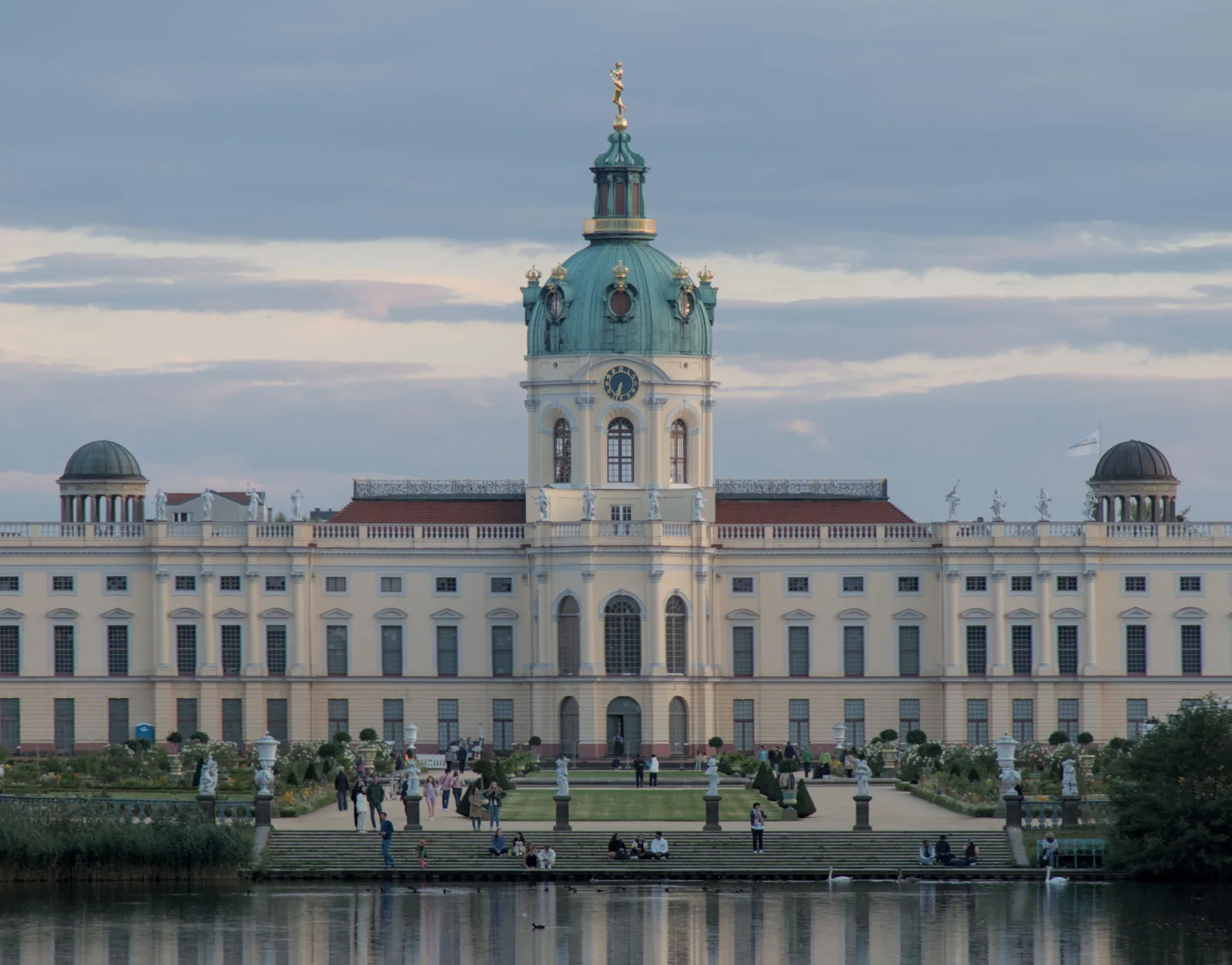 Elegant view of Charlottenburg Palace in Berlin with reflection in water, capturing its baroque architecture.