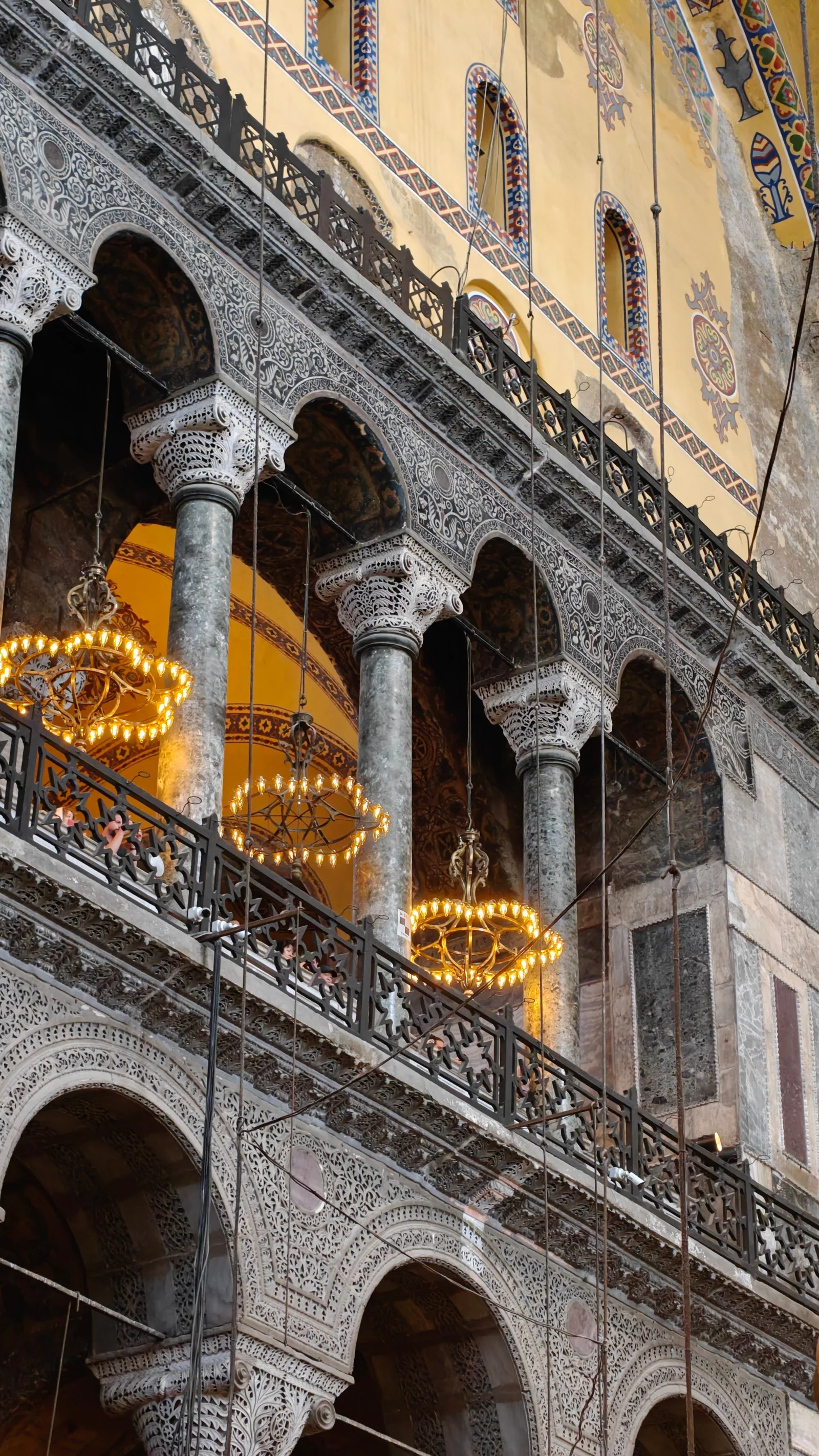 Elegant architectural details of Hagia Sophia with chandeliers and intricate arches.