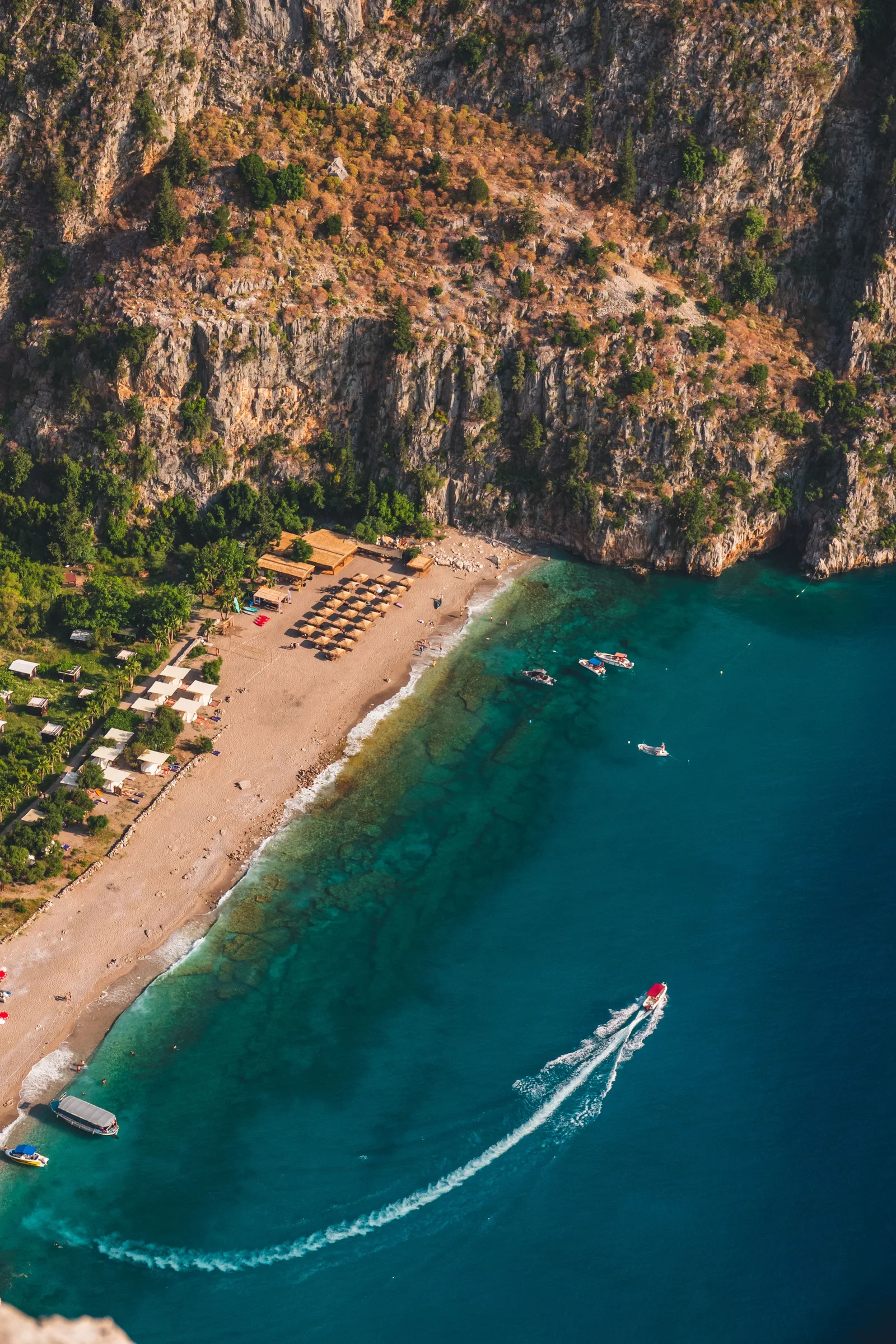 Breathtaking aerial shot of Ölüdeniz Beach in Muğla, Türkiye with boats and turquoise water.