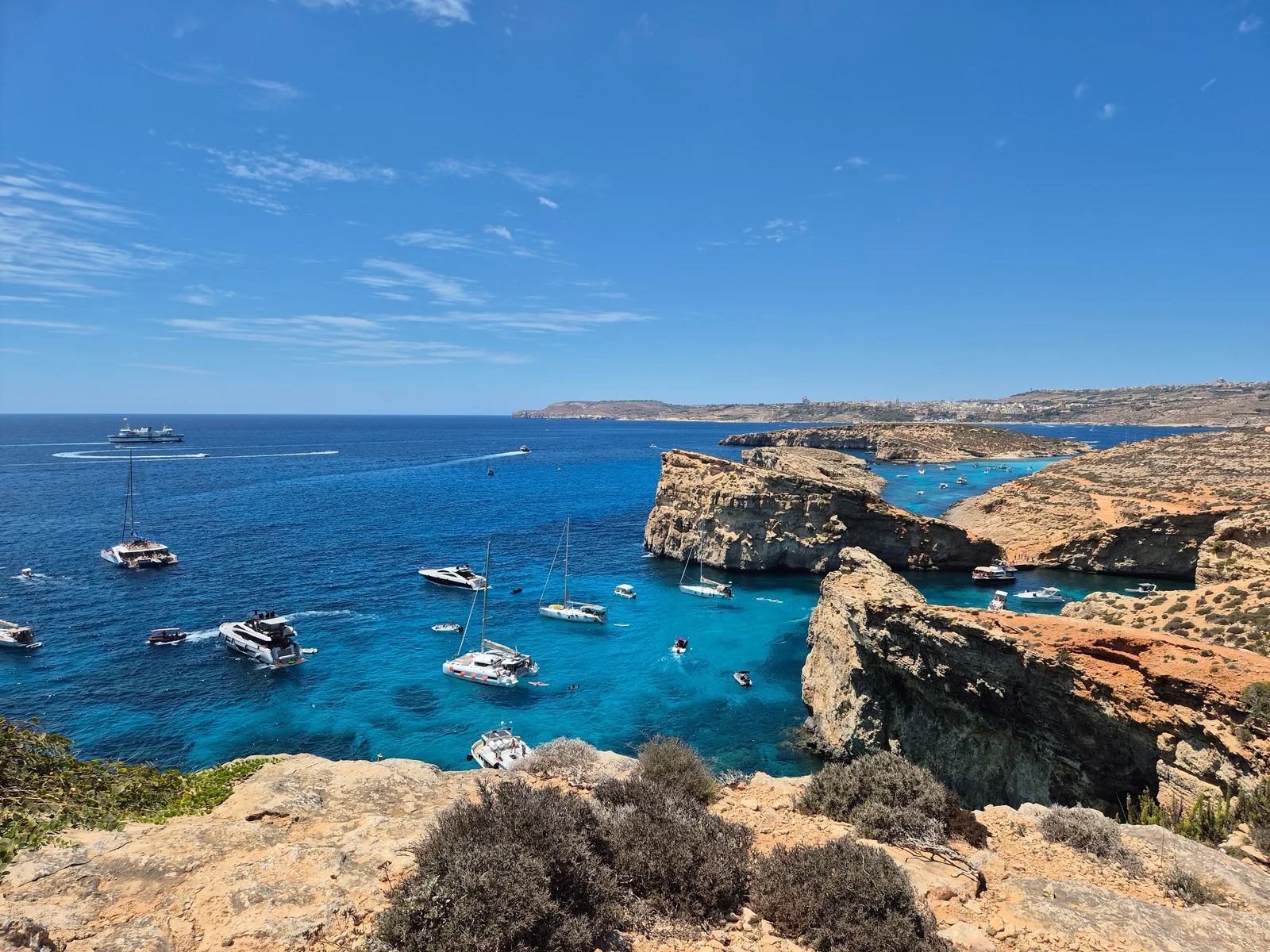 A breathtaking view of Comino Island's Blue Lagoon with boats and clear blue waters.